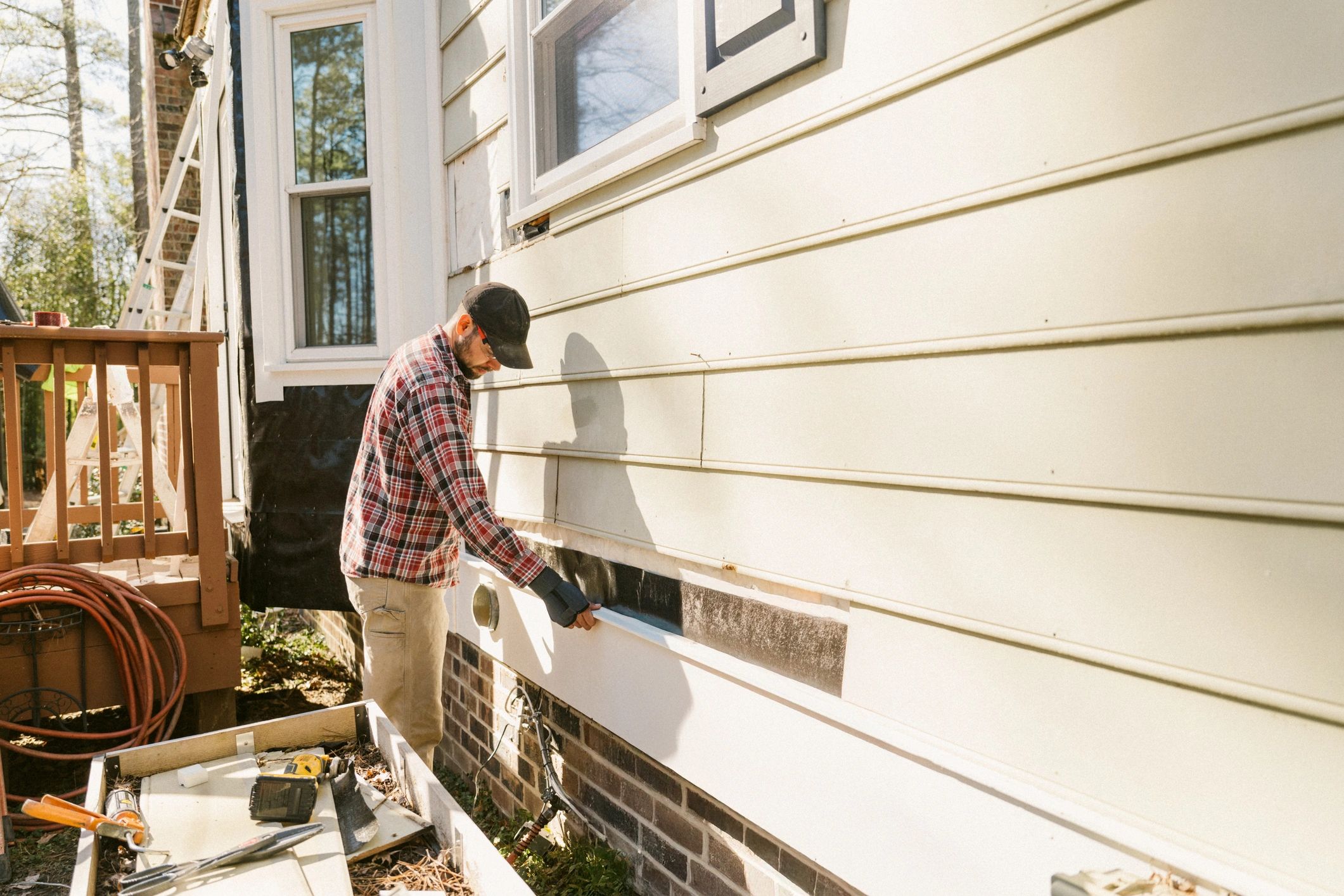Technician performing exterior home service work